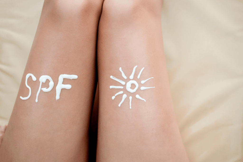 the letters SPF and a sun drawn in suncream on legs
